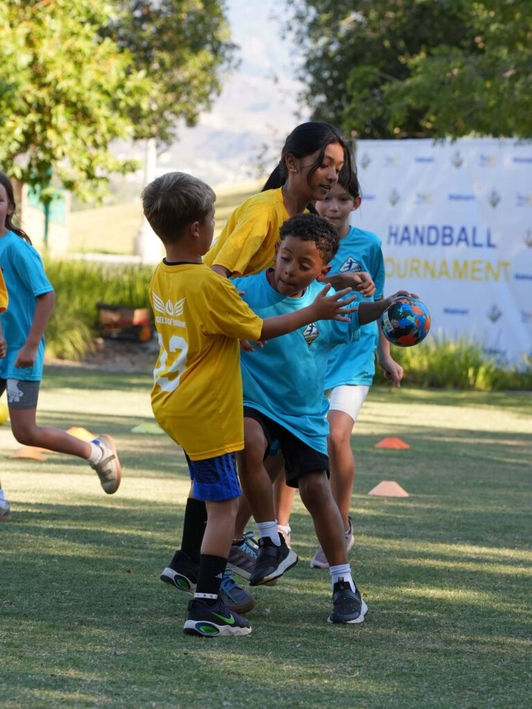 Young handball players competing for the ball during the tournament