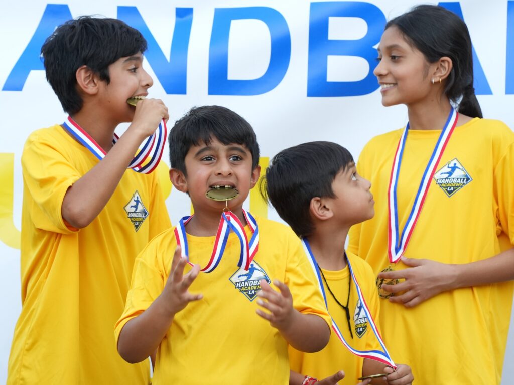 Young handball players celebrating with their tournament medals